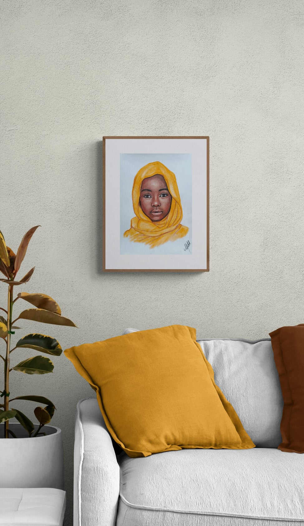 Framed portrait of a person wearing a yellow headscarf on a wall above a white sofa with yellow and brown cushions.