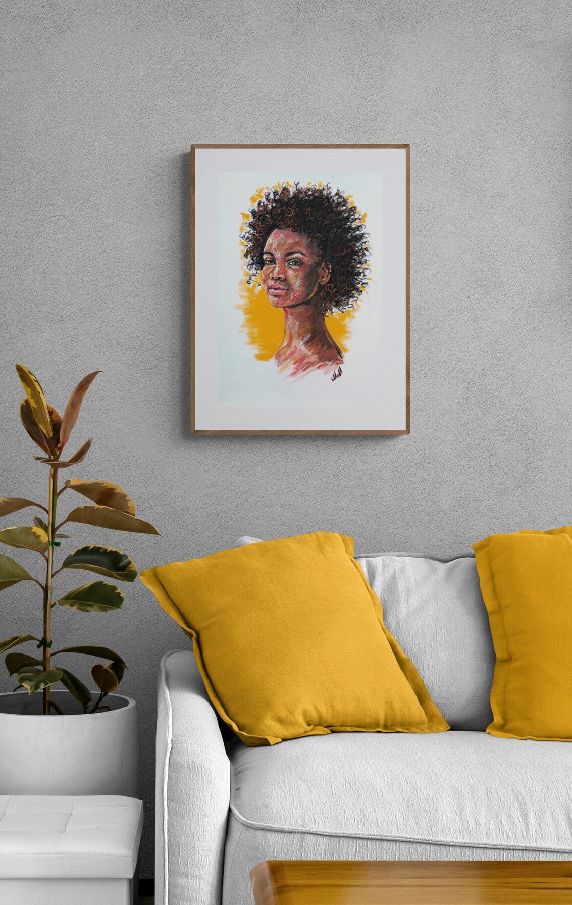 Framed portrait of a woman above a white sofa with yellow cushions.