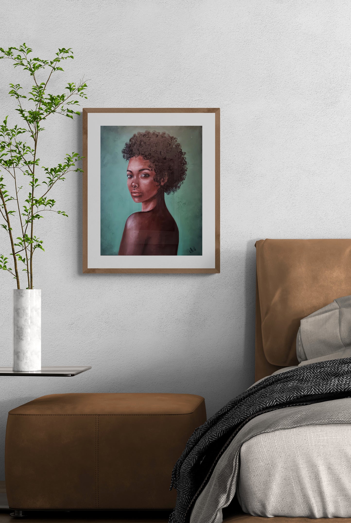 Framed portrait of a woman on a wall above a bed in a bedroom setting.