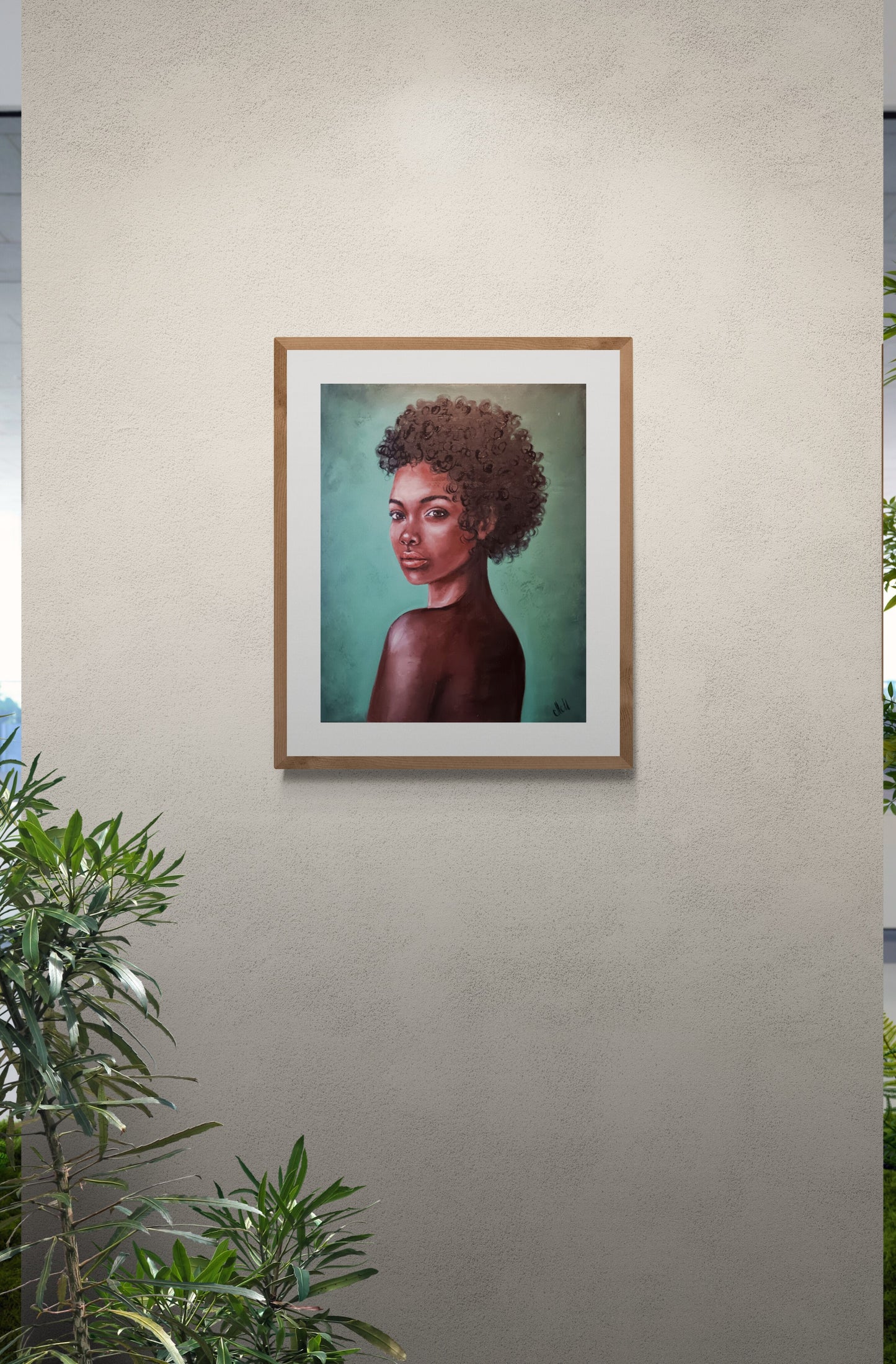 Framed portrait of a person with an afro on a beige wall with plants below.