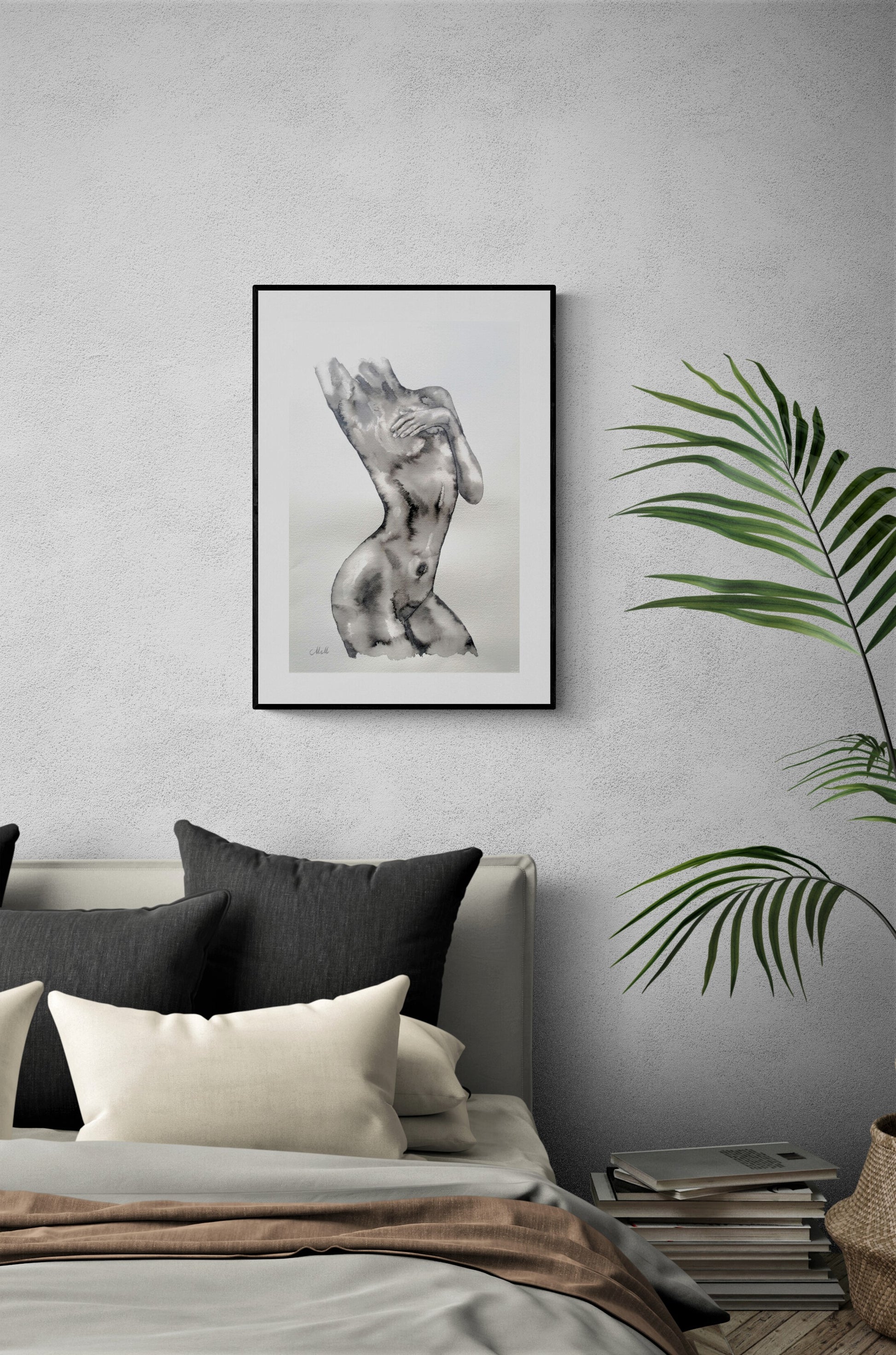Framed artwork of a nude figure on a gray wall above a bed with pillows.
