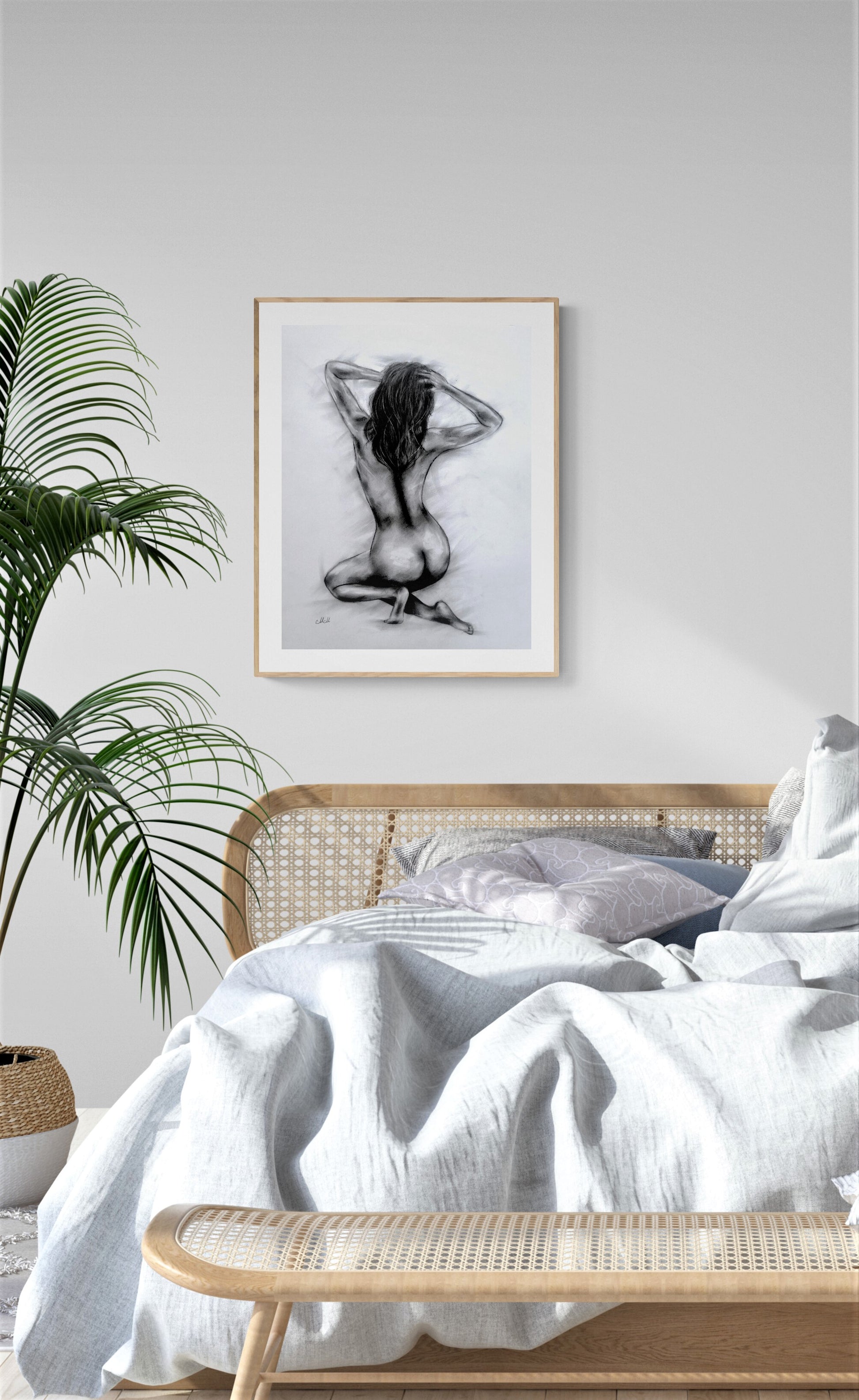 Bedroom with a framed black and white artwork on the wall, a bed with white bedding, and a plant.