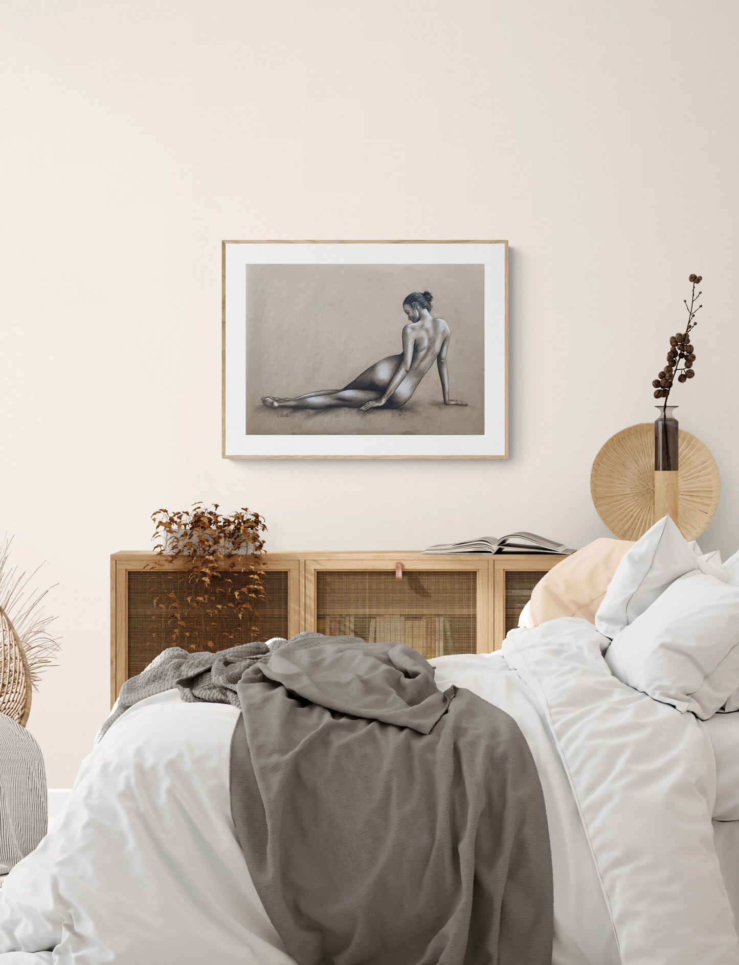 Bedroom with a bed, gray blanket, and framed artwork on the wall.