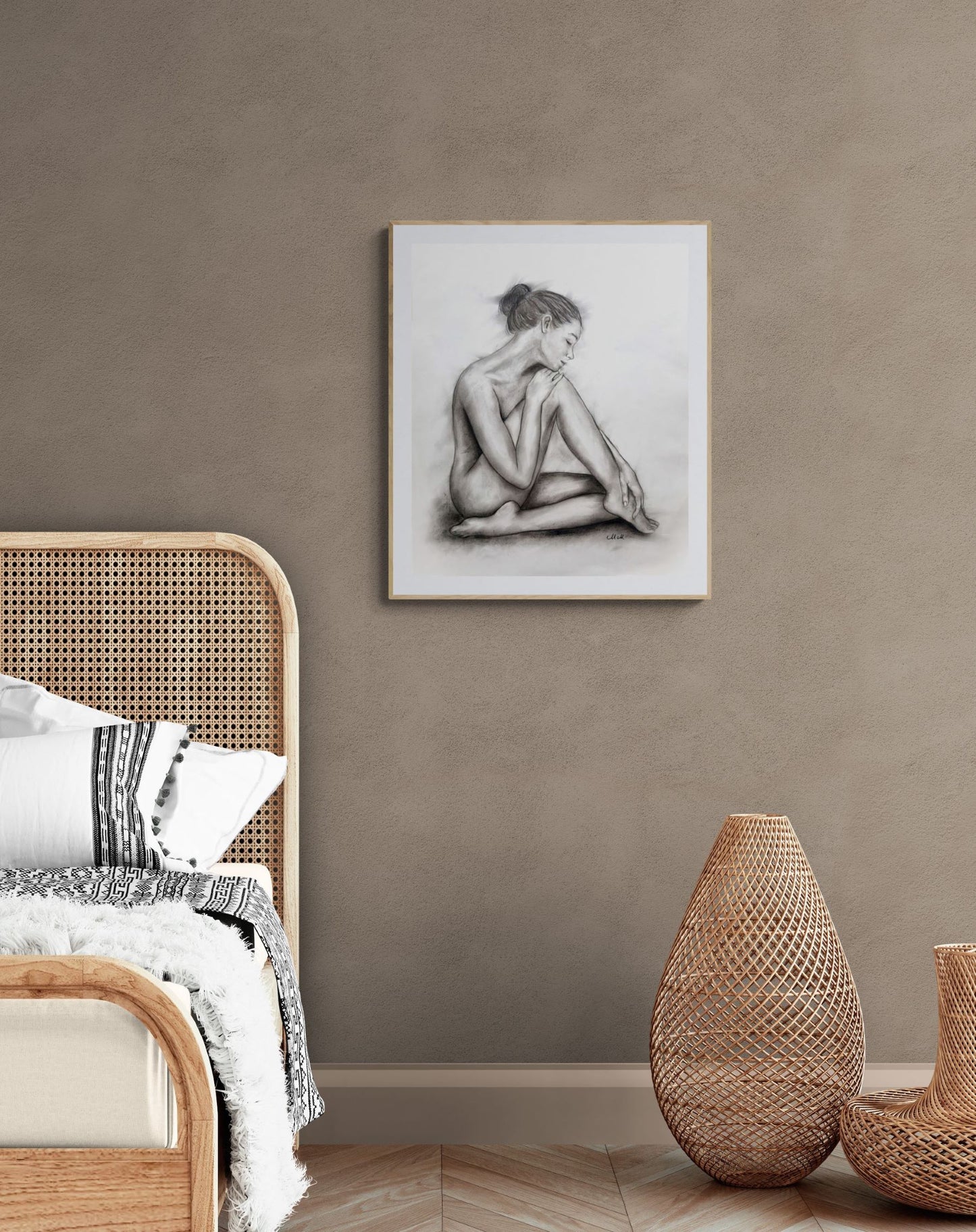 Room interior with a wicker chair, woven vases, and a framed black and white artwork on the wall.