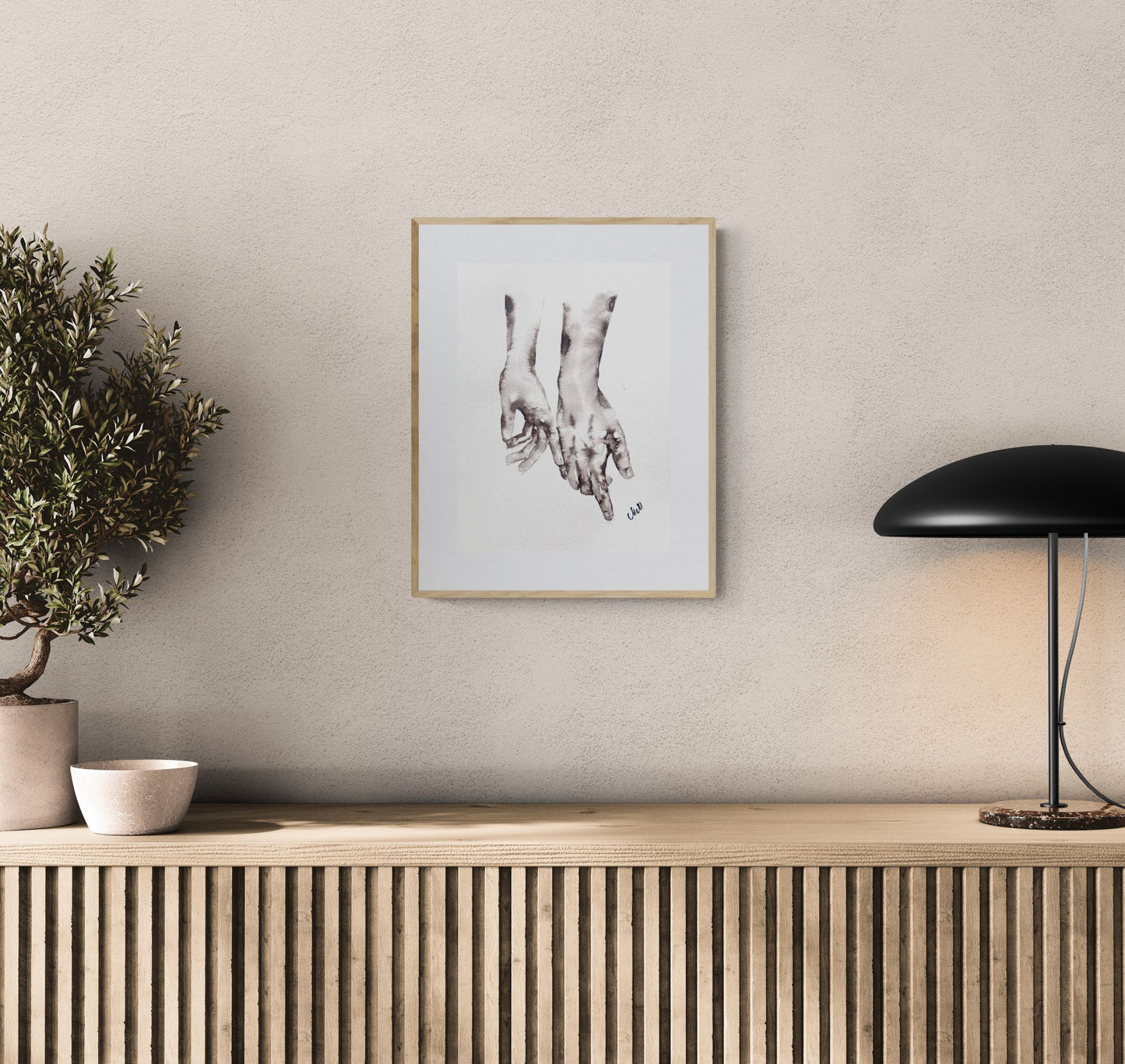 Framed artwork on a wall above a wooden console table with decorative items.