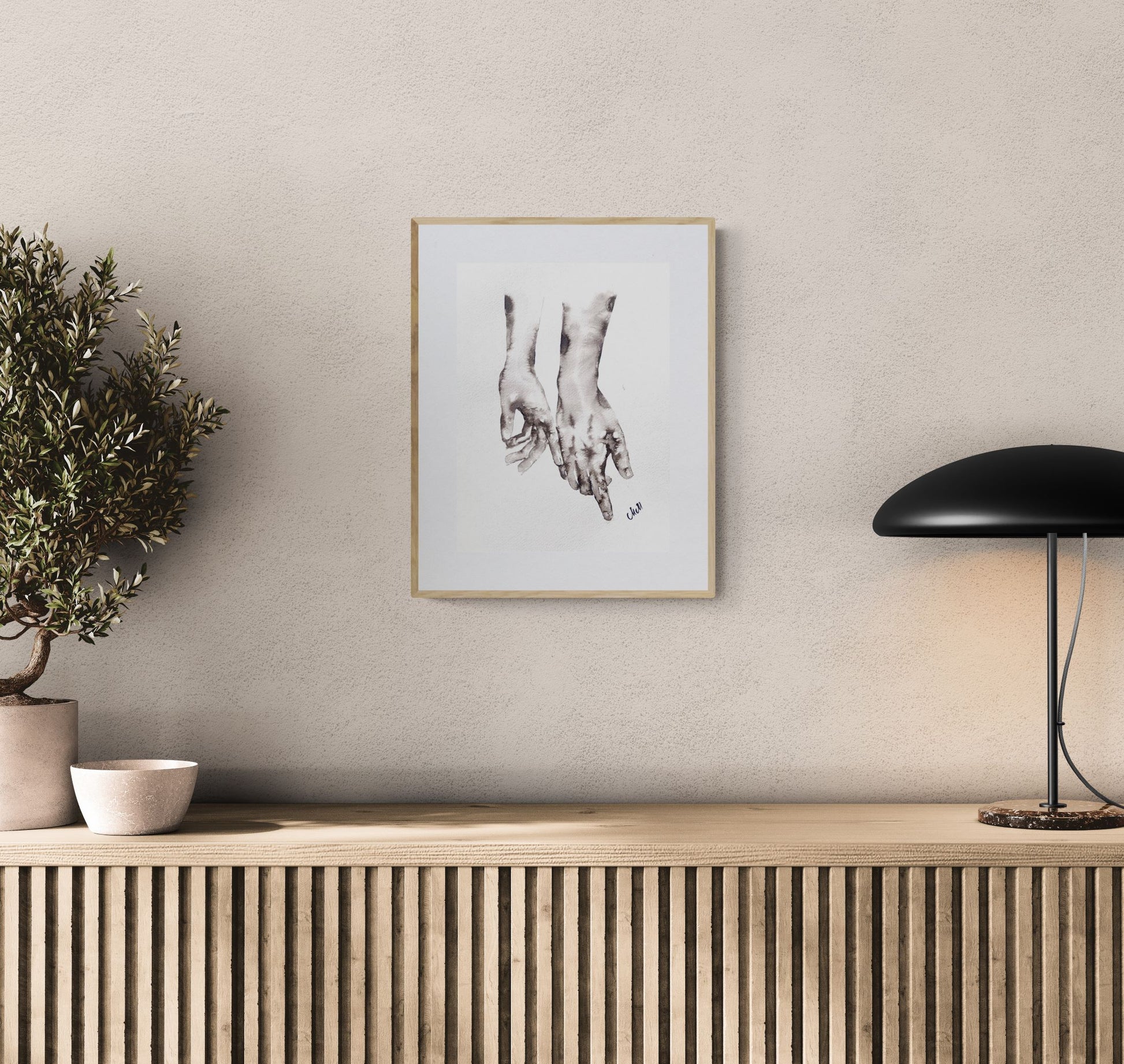 Framed artwork on a wall above a wooden console table with decorative items.