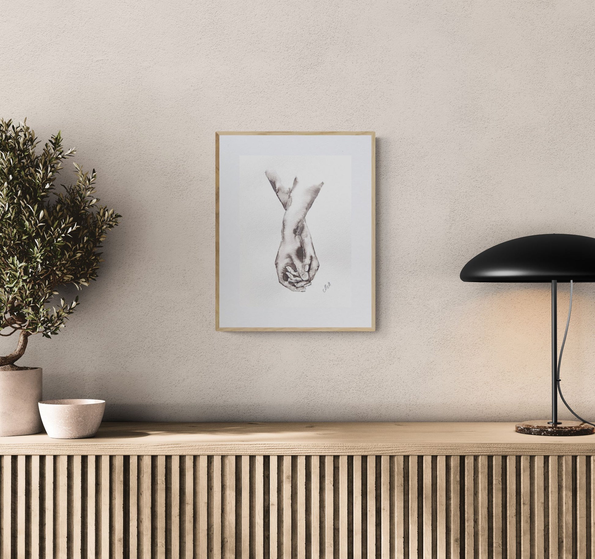 Framed artwork on a wall above a wooden console table with decorative items.