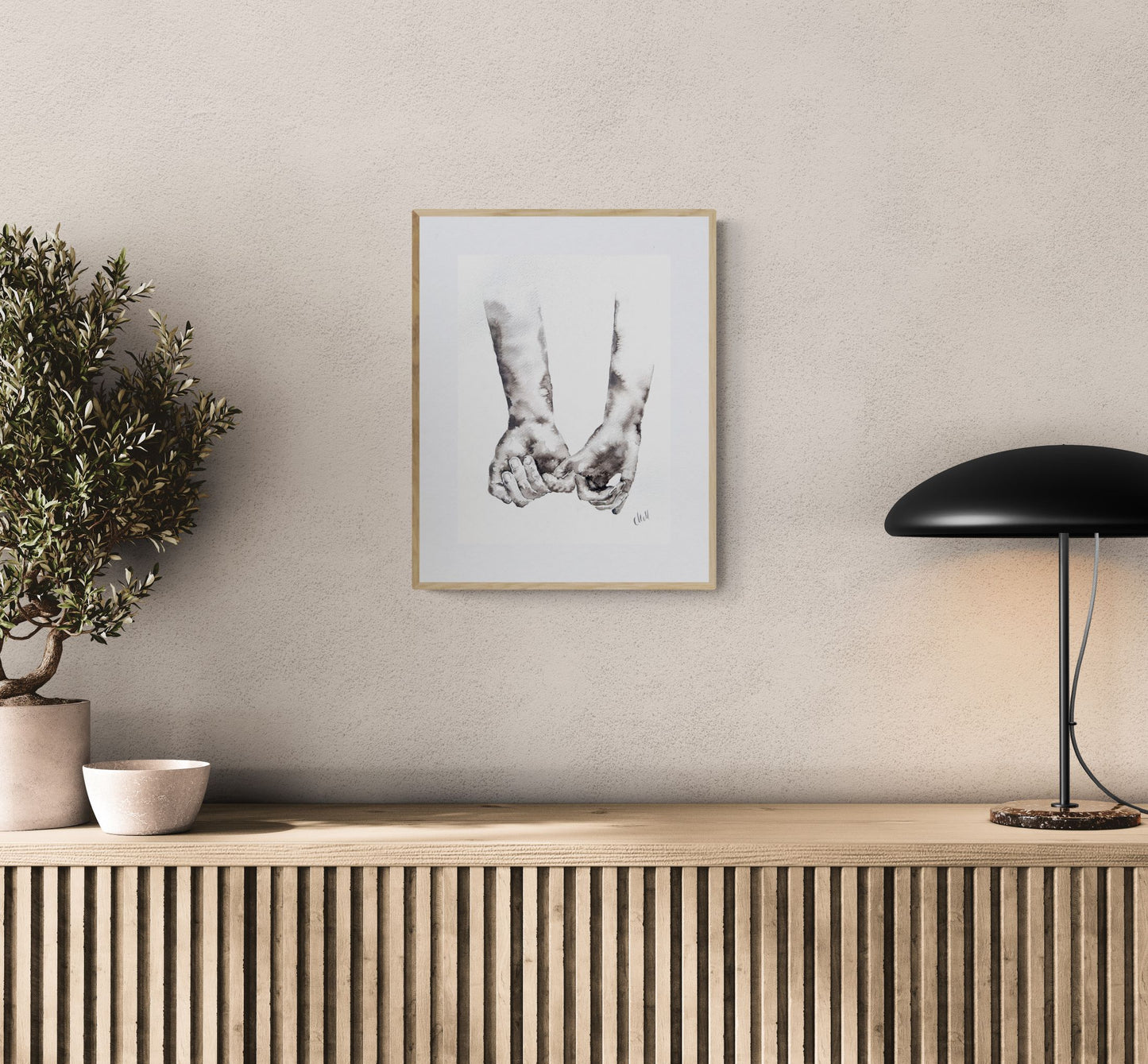 Framed artwork on a wall above a wooden console table with decorative items.