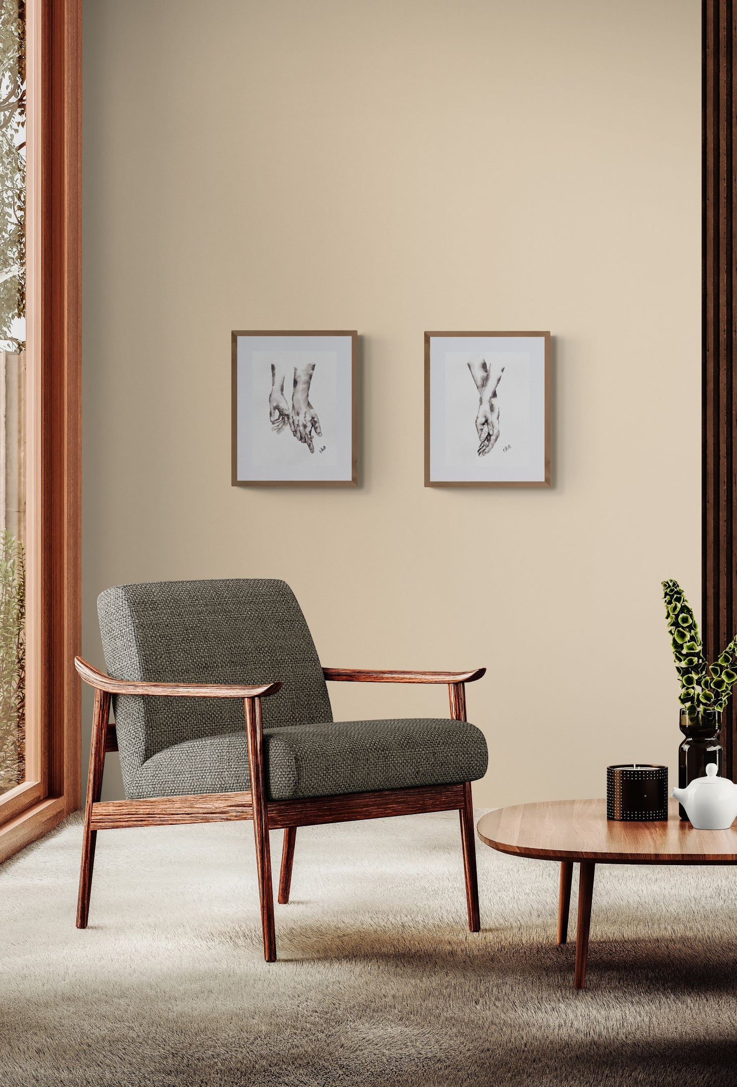 Gray armchair in a living room with framed pictures on the wall and a small table.