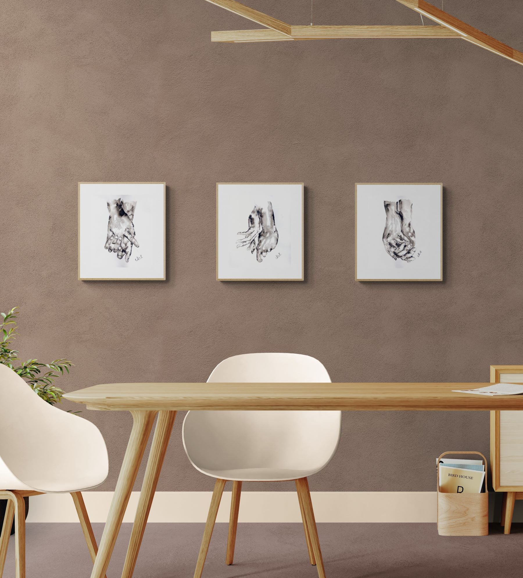 Modern dining room with a wooden table and chairs against a brown wall with framed artwork.