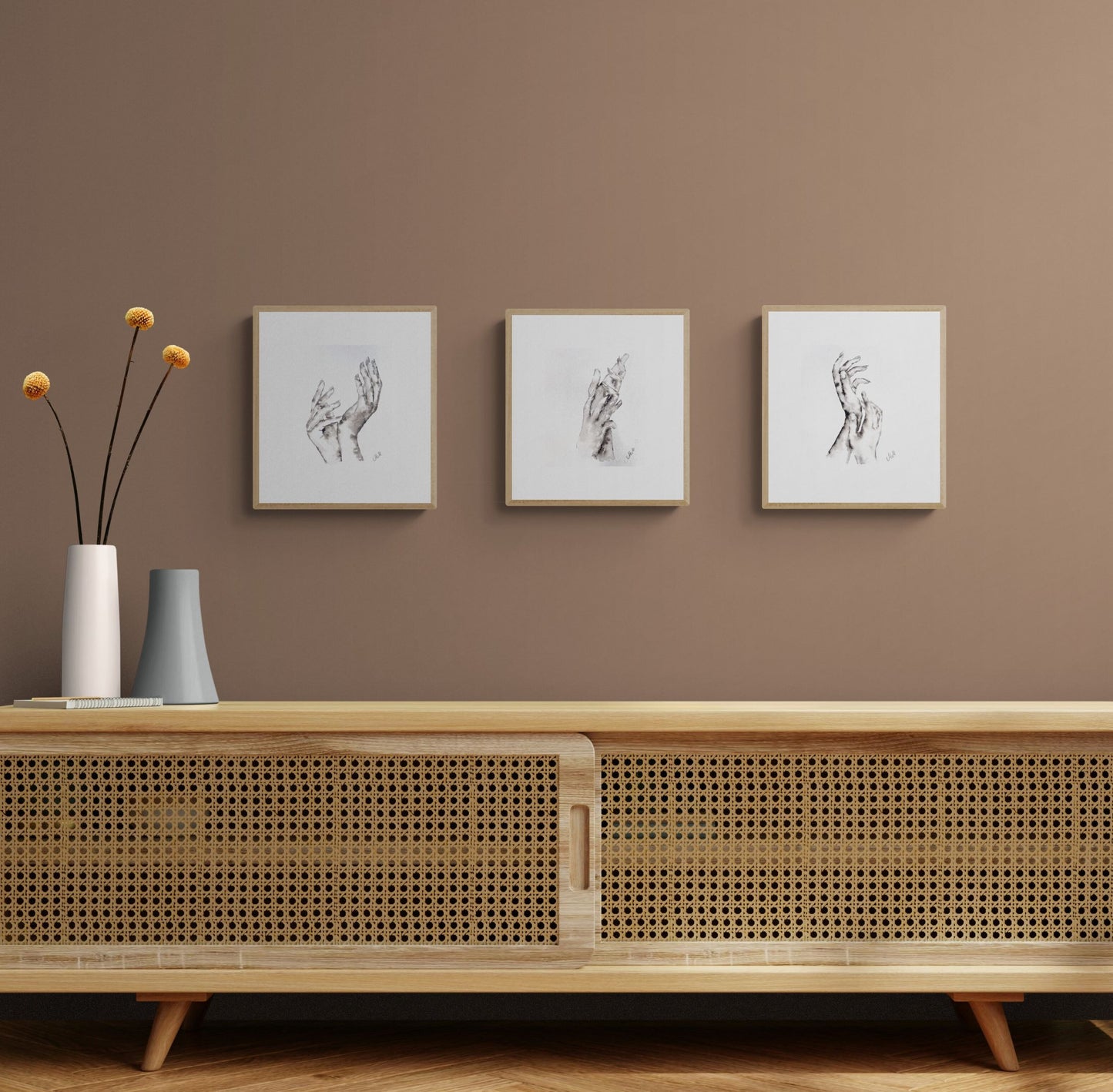 Wooden cabinet with decorative vases and framed art on a brown wall