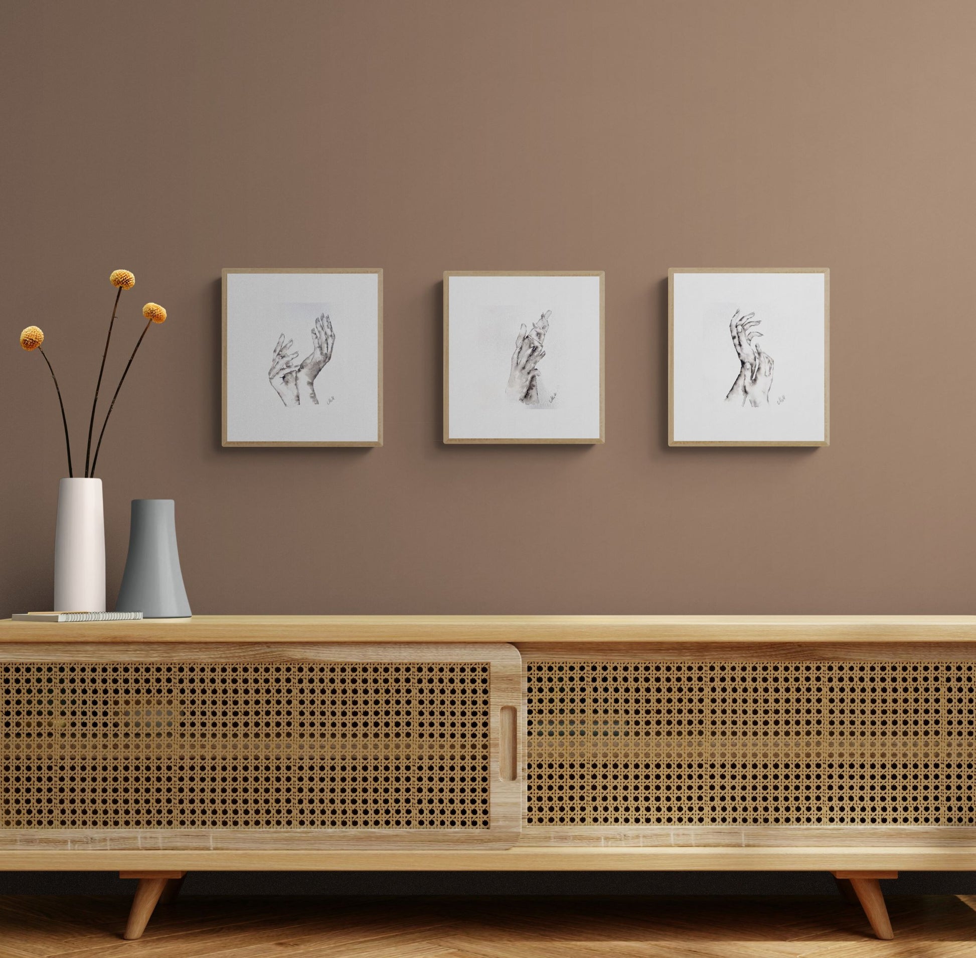 Wooden cabinet with decorative vases and framed art on a brown wall