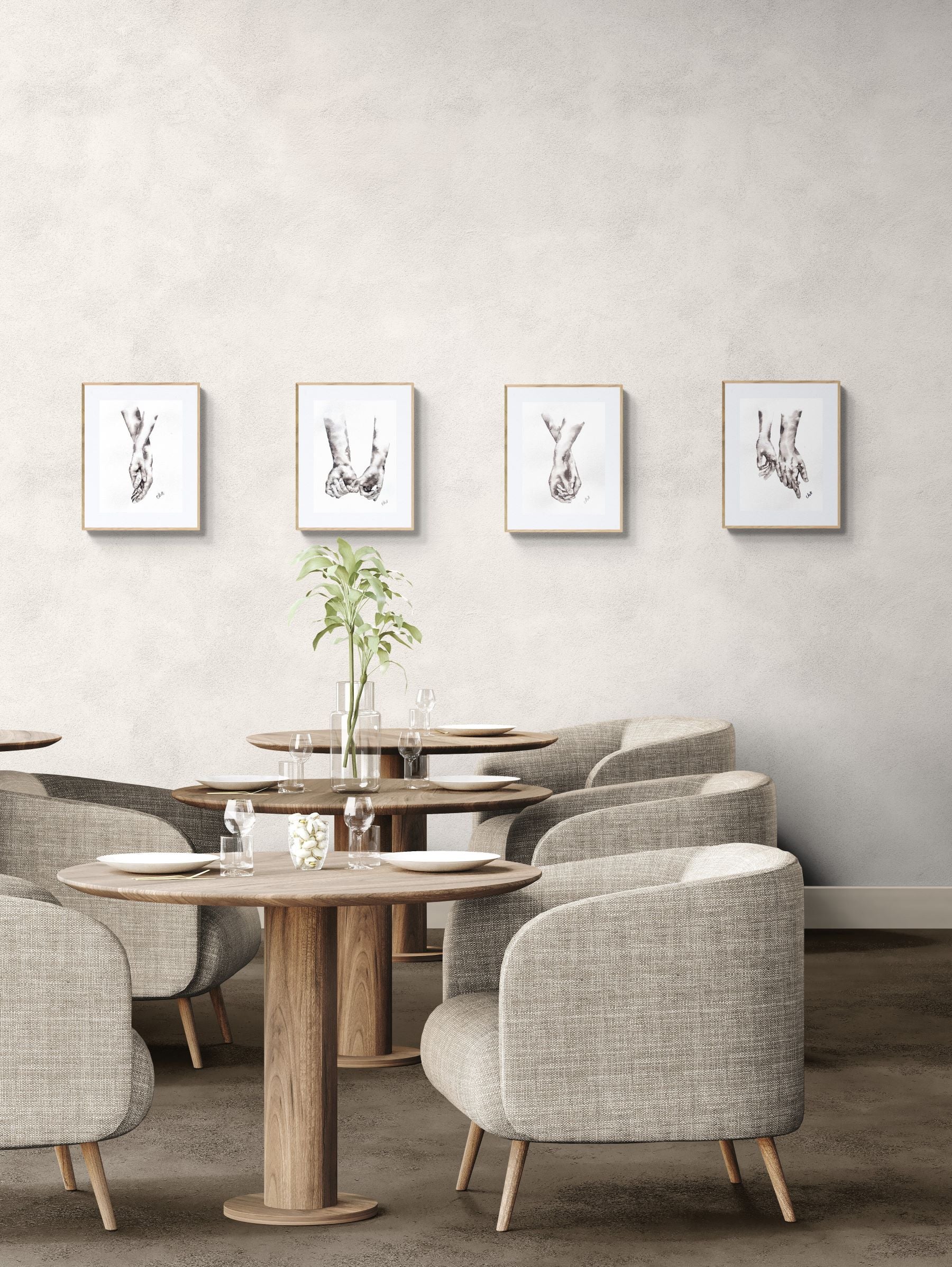 Dining area with round wooden tables and gray chairs against a light gray wall with framed pictures.