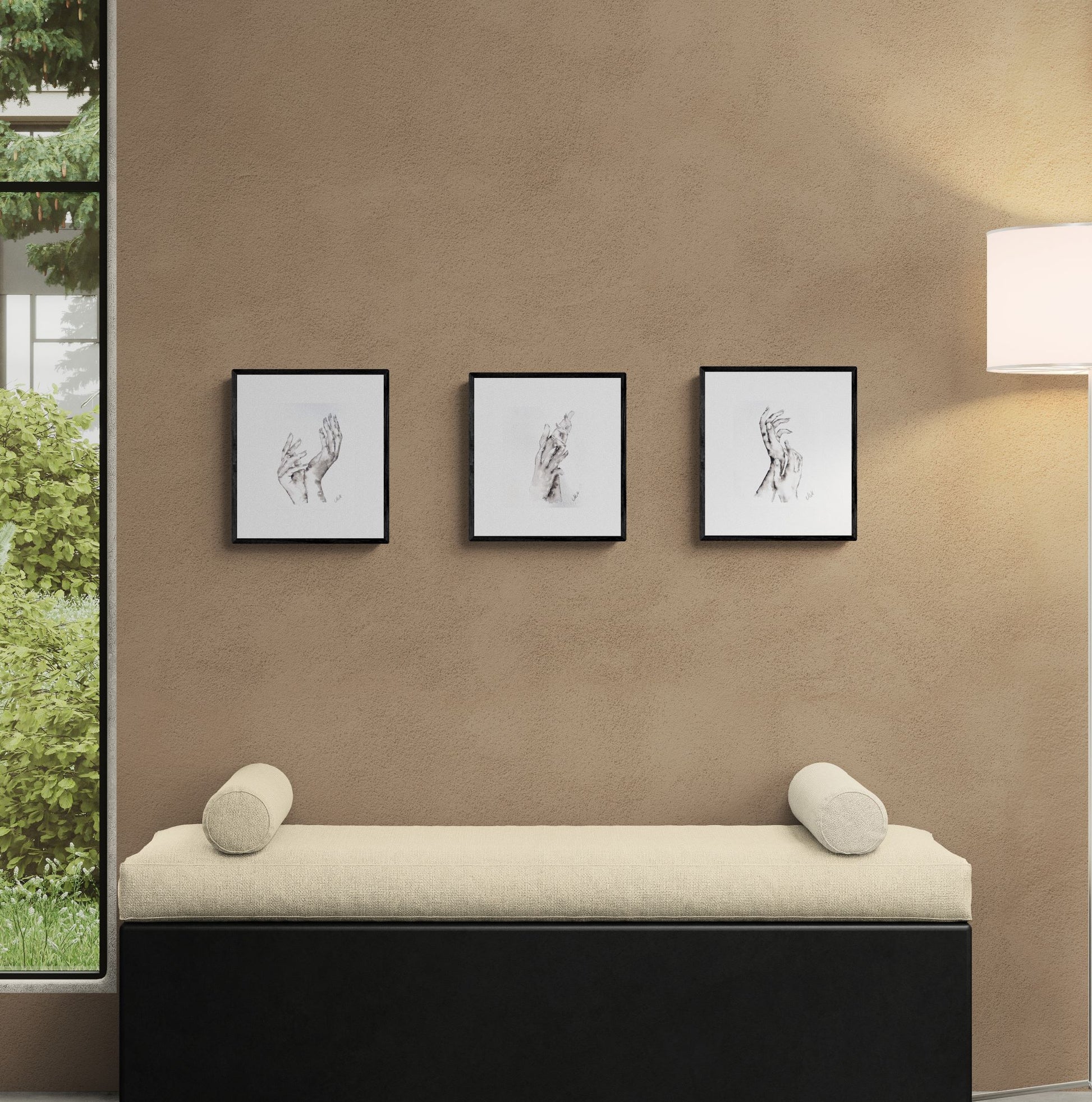 Beige bench with cylindrical cushions against a brown wall with three framed black and white artworks.